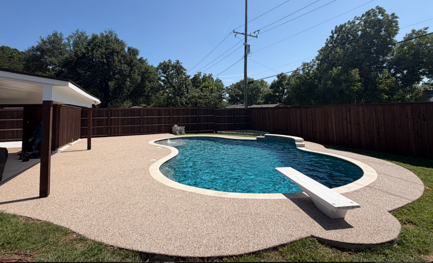 Wide view of a completed rubber surfacing installation around a residential pool
